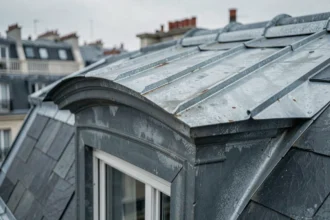Chien assis en zinc sur toiture parisienne avec détails de pliage et oxydation naturelle