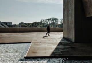 person walks near pillar